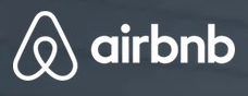 Airbnb logo on the 2014 airbnb.com homepage: the Bélo symbol, white over the photo (July 2014 rebrand)